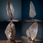 **on display. A random piece of crystal art in the style of Abstract Expressionism art period artists. This crystal has been cracked and broken. The large repair along the side of the quartz is of turquoise stone used to mend it. The base has patina copper and layered black rock. The base is adorned with carved magical sigils. High-end, high-quality cultural design. --c 85 --s 700 --w 450 --v 7.0** - <@923747341717078036> (fast)
