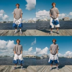 **A young handsome tan skinned white man with light brown hair cut short in a wavy shaggy hairstyle dressed in a Y2K Cholo gangster style, wearing a Shaka grey t shirt and extremely baggy, extra-long, 3XL plain white and blue Jordan basketball shorts. He is wearing Nike shoes standing on a dock in Jacksonville Florida. His shorts go down to his feet touching the ground and his shoes --v 7.0** - Variations (Strong) by <@1061360796438900746> (fast)