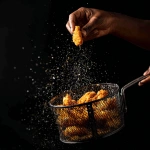 **a black person's hand holding the handle of a fish frier basket tossing freshly fried fish in the air from the fryer basket. Against a black background. --v 7.0** - Image #4 <@817880507983069194>