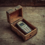**nostalgic 1990s mobile phone locked inside a wooden box, analog unplug concept, peaceful still life, muted earthy tones, vintage atmosphere --no text** - Image #4 <@1282642039275655180>