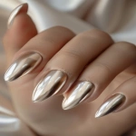 **matte champagne chrome nails with glossy chrome edge, texture contrast manicure, sculptural almond shape, photographed in nail studio lighting, pro nail artist design, soft neutral background, editorial fashion hands --v 6.0 --ar 2:3 --raw** - Image #1 <@1321895242076520463>