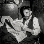 **abrahm vermont, un escritor adulto de 30 años en 1915 en rosario duermiendo acostado en el piso de noche. se tapa con diarios porque no tiene frasada. cubierto por los ejemplares de diario como sabana. 'the vols stimme' su diario escrito en idish litografiado. Vive entre sus palabras en su cuarto muy pequeño de conventillo y con pocas cosas, para escribir y litografia. Escena de pelicula a color de thirller moderno ambientado en 1910 pero con la calidad actual de cine profesional. Vermont es dejado, tiene bigote largo pero sin barba y poco pelo y un poco gordo, viste formal, pero gastado.** - Image #3 <@985959374633717780>