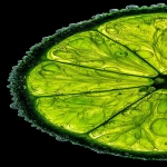 **ultra-close macro of a key lime slice, positioned tight against the right margin, about two-thirds visible, left side empty black negative space; bright neon-green translucent pulp, glowing under strong backlight, thin rind with subtle grain; natural micro-droplets (0.3-0.8mm) along rind edge, none floating; clinical food macro lighting, polarizing filter, sharp texture of juice vesicles, hyperreal color contrast --ar 59:128 --v 7.0 --q 2 --p mt1858g** - Upscaled by <@762546997382348820> (relaxed)