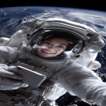 **The photo should be hyperrealistic but with distorted proportions. The framing should distort the proportions, prioritizing the head and shrinking the legs and feet. A 40-year-old female astronaut is on a spacewalk, having fun, smiling, and wearing a transparent helmet. In the background is planet Earth. She is holding a smartphone in her right hand and looking at the screen. Focus on the arm and the phone in the foreground. Use of a wide-angle lens. Natural light, surreal photo, crazy proportions. --ar 9:16** - Image #1 <@1310560084346146826>