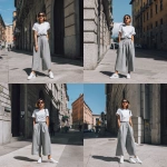 **a woman in grey wide-leg pants, white sneakers, and a t-shirt outfit is standing on the street, wearing the shoes and looking at the camera, with the focus on her legs.** - Variations (Strong) by <@1198884420749377556> (fast)