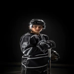 **Upper body portrait of a charismatic 14-year-old Canadian male ice hockey player, wearing a modern black and silver uniform with chrome accents and a bold NHL-style bear logo on the chest, black gloves, helmet with clear glass visor. Charismatic, confident, determined expression, youth NHL rookie energy, styled like an official NHL promotional poster. Ultra-realistic dramatic sports photography, cinematic studio lighting with bold contrast, HDR effect, sharp detail, intense focus. Captured with a Sony α7R IV camera, 85mm lens, f1.2 aperture --ar 2:3 --raw --v 6.1** - Image #3 <@1007029574430892245>