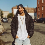 **A handsome fit white Italian man wearing a crisp white t-shirt ' ripped light blue slim jeans, air Jordan 1'Sa gold cross Chain, a backwards Mets hat and a black puffer jacket. The man is about 19 years old with tan skin and dark brown hair. He should be standing on a street In queens.** - Image #2 <@925555162267922472>