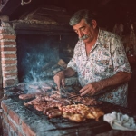 **grumpy Portuguese mustachio'd old man grilling delicious barbecue assorted meats, sausages and chicken over hot coals in a brick barbecue oven, wiping the sweat off his brow with tiny towel, with tanabata-inspired print shirt, photo taken with provia** - Image #4 <@538878031226470440>