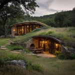 **An earth-embedded home in the style of lake flato architects. The home is built into a small hillside, with southern windows overlooking a meadow akin to the coastal regions of New England. Add some hobbiton accents to the earth home** - Image #2 <@1182158818818400348>