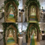 **The tunnel structure is made of thin support poles from a garden arch measuring 1.5 meters in height, 1.2 meters in width, and 5 meters in depth. Inside the entrance of the cardboard arch, the exterior is decorated with a forest interior, and a path made of thin rainbow-colored vinyl tape is depicted on the floor.a cotton cloud canopy, and an interior resembling library shelves mapped onto cardboard at the end of the forest. A children's attraction interacting with a server station is installed by covering office desks and displays with fabric, placing them in the pathways between desks, removing desk chairs to create pathways, and masking the lower parts of desks with green curtains. Cardboard guardrails are installed up to waist height, creating a bright and cheerful atmosphere. --ar 4:3 --v 7.0** - Variations (Strong) by <@580349603761750038> (fast)