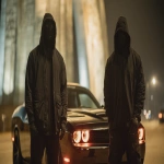 **2 St. Louis Based Rappers, wearing all black, black masks and hoods, gloves, up close and personal 8k professional photography shoot for an album cover, low light night time dynamic and cinematic. Under the Gateway Arch Standing by a black Trackhawk and a black Hellcat --ar 16:9 --v 7.0 --raw** - Upscaled by <@1060379121521279086> (fast)