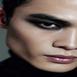 **full-face portrait of a fashionable 30-year-old Taiwanese man, long-shaped face, fair pale skin, thick eyebrows, large expressive double-lidded eyes, and naturally full lips, with softly contoured cheeks not sunken; styled with bold high-fashion smokey eye makeup in deep gray and black tones, paired with glossy lip color for a striking contrast; contemporary hairstyle with clean lines, cinematic editorial lighting highlighting makeup and hair details, blurred neutral background, sharp focus on facial features, refined fashion magazine aesthetic, no text, no watermark --ar 9:16** - Image #1 <@1090872516857299025>
