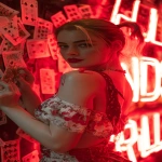 **Harley Quinn leaning against a wall of neon red signs, mischievous grin, red lipstick and smudged makeup, holding a deck of playing cards that scatter in the air, glowing red atmosphere, dramatic and suggestive, cinematic composition, space for lyrics --ar 9:16 --v 7.0** - Image #4 <@257221362568003584>