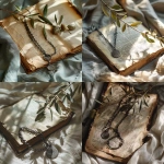 **An oxidized silver chain with sigil charm, arranged loosely across an open antique book with yellowed, frayed pages. Natural light falls softly from the right, highlighting texture in both metal and paper. A dried olive branch rests above the chain. Background includes linen in pale smoky green. Composition is asymmetrical and breathing, mood is quiet, intentional, spiritual chic. --v 6.0** - <@1214240647834509406> (relaxed)