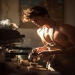 **a young boy inspired by Ganymede, working as a barista in a modern café, gently pouring coffee into a cup for a customer, wearing a loosely tied apron, fit and graceful build, nice chest, nice abs, warm morning sunlight, soft golden highlights on his face and arms, classical Greek design motifs subtly integrated into the café interior, cinematic photography, --ar 2:3** - Image #2 <@358254535862648853>