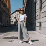 **a woman in grey wide-leg pants, white sneakers, and a t-shirt outfit is standing on the street, wearing the shoes and looking at the camera, with the focus on her legs.** - Image #4 <@1198884420749377556>