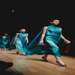 **In the middle of a fashion show runway, a full-body photo of models wearing teal-colored satin long sleeveless draped dresses with high necks and shoulder-caped capes, mini bags on their arms, black stiletto heels, and glittery polka dot shoes, shot from an iPhone in low light, and posted to Instagram in the style of raw v5.2.3. --ar 59:128** - Image #3 <@1244833739805036605>