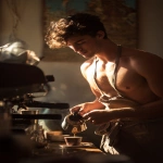 **a young boy inspired by Ganymede, working as a barista in a modern café, gently pouring coffee into a cup for a customer, wearing a loosely tied apron, fit and graceful build, nice chest, nice abs, warm morning sunlight, soft golden highlights on his face and arms, classical Greek design motifs subtly integrated into the café interior, cinematic photography, --ar 2:3 --v 7.0** - Upscaled by <@358254535862648853> (fast)
