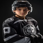 **Upper body portrait of a charismatic 14-year-old Canadian male ice hockey player, wearing a modern black and silver uniform with chrome accents and a bold NHL-style bear logo on the chest, black gloves, helmet with clear glass visor. Charismatic, confident, determined expression, youth NHL rookie energy, styled like an official NHL promotional poster. Ultra-realistic dramatic sports photography, cinematic studio lighting with bold contrast, HDR effect, sharp detail, intense focus. Captured with a Sony α7R IV camera, 85mm lens, f1.2 aperture --ar 2:3 --raw --v 6.1** - Image #3 <@1007029574430892245>