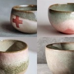 **Photorealistic close-up of an elegant handmade ceramic cup, inspired by nature and calmness, organic shape, soft textures, subtle imperfections, gentle pastel color palette (muted beige, soft sage, pale blush), matte-to-silk glazed surface. A soft, realistic reflection of the Danish flag (red flag with white cross) visible in the glaze, subtle and abstract, not literal or dominant. Scandinavian aesthetic, natural diffused daylight, minimalistic composition, shallow depth of field, ultra-high detail, realistic shadows, professional studio photography 16:9 raw --v 7.0** - <@1062788114764013599> (fast)