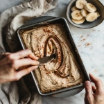 **Top-down view of banana bread batter in a loaf pan with thick cinnamon sugar swirl being dragged through the batter using a knife, visible layers and ribbons of cinnamon, rustic baking scene, soft daylight, hands in action, cozy homemade baking vibe --v 6.0 --ar 4:5 --raw** - Image #2 <@1321895242076520463>